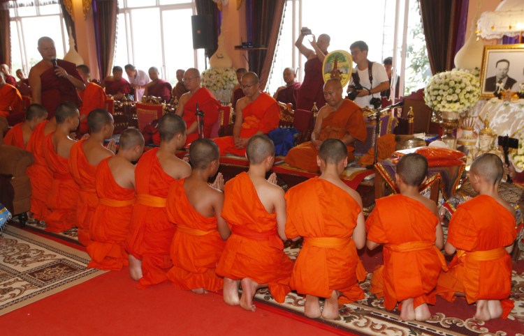 Members of the Wild Boars soccer team pray Saturday as they complete service as novice Buddhist monks. 