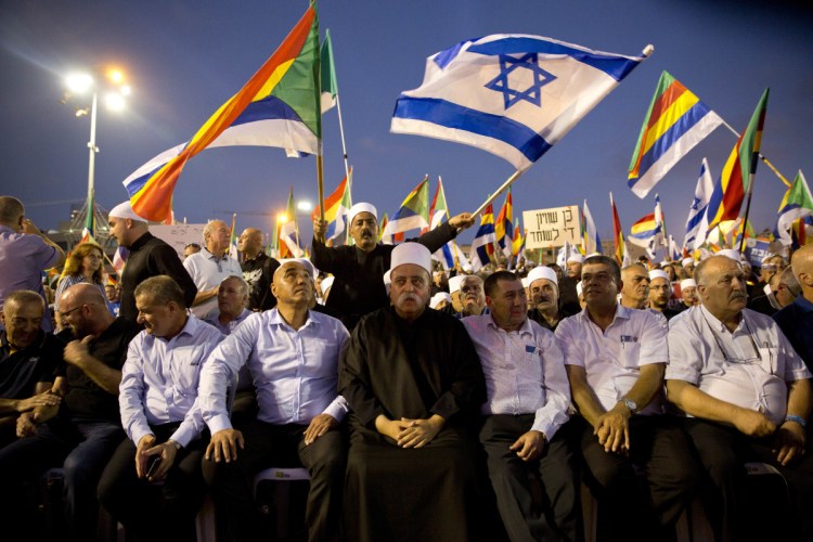 Druze spiritual leader Sheik Mowafaq Tafik, center, sits during a rally against Israel's Jewish Nation bill in Tel Aviv on Saturday. 