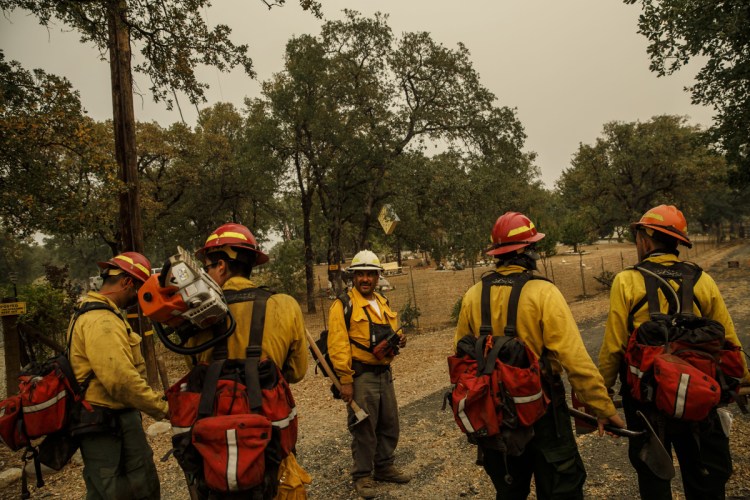 Frederico Rocha Sr., center, leads his firefighters as they mop up hot spots near homes in Redding, Calif., on July 30. "When people appreciate what we do, it makes us feel good," Rocha said. "Even at stores, people thank us and they're happy we're helping."