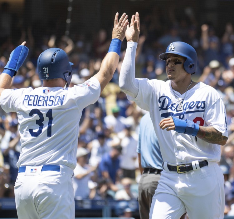 Joc Pederson, left, and Manny Machado celebrate Sunday after scoring on a two-run double by Brian Dozier during the Dodgers' 3-2 victory against the Astros.