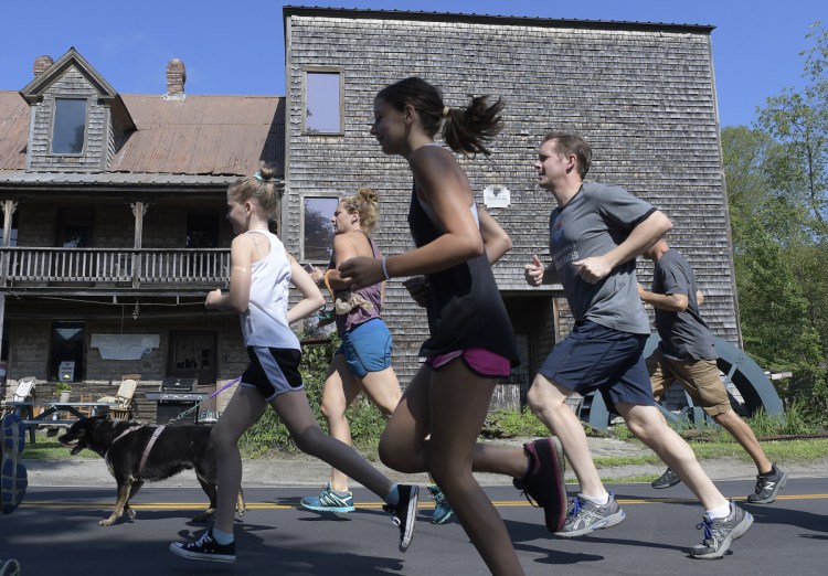 Runners sprint past the old grist mill Sunday in downtown Mount Vernon at the start of the Loon Lap, a 5K walk and run around Minnehonk Lake. Temperatures were in the mid-80s during the event, which raises funds for the Greater Minnehonk Lake Association and Mount Vernon Community Partnership.
