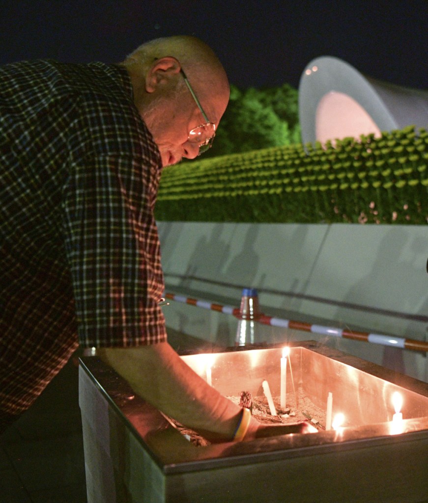 A man burns a stick of incense at the cenotaph dedicated to the victims of the atomic bombing at Hiroshima Peace Memorial Park in Hiroshima, western Japan, early Monday, marking the 73rd anniversary of the attack. (Yohei Nishimura/Kyodo News via AP)