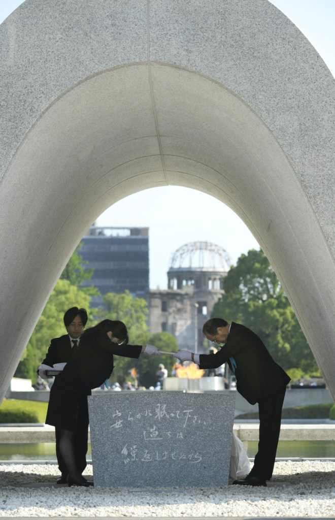 Hiroshima Mayor Kazumi Matsui, right, dedicates the list of the victims of atomic bombing to the cenotaph during a ceremony to mark the 73rd anniversary of the bombing at Hiroshima Peace Memorial Park in Hiroshima, western Japan, Monday. Matsui raised concerns in his peace address about the rise of egocentric policies in the world and warned against the idea of nuclear deterrence as a threat to global security. The Atomic Bomb Dome is seen in the background. (Yohei Nishimura/Kyodo News via AP)