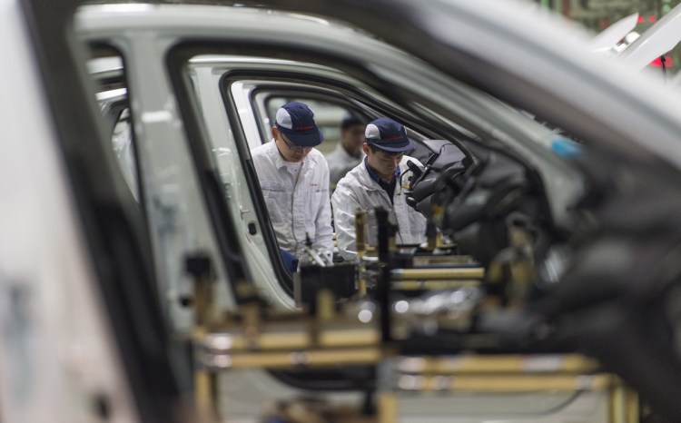 Workers assemble cars at the Dongfeng Honda automotive plant in Wuhan in central China's Hubei province in this 2017 photo. China's auto sales shrank by 5.3 percent in July 2018 from a year earlier, signaling economic malaise amid a tariff battle with Washington.