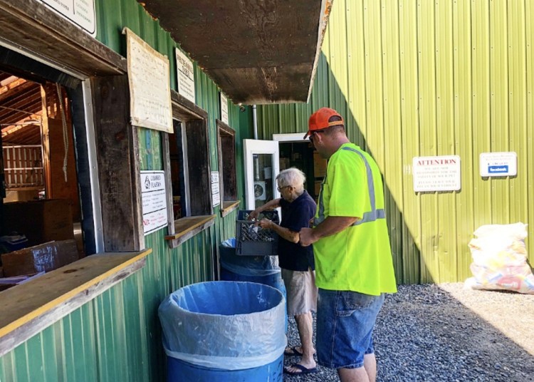 Unity Area Regional Recycling Center manager Stanley Besancon helps Betty Gross of Unity sort her recyclables Friday in Thorndike. "The market has been bad for about a year now," he said, "especially with China reducing the imported recycling from the United States."