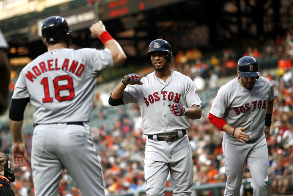 Xander Bogaerts, center, celebrates with Mitch Moreland, left, and J.D. Martinez after hitting a three-run homer in the first inning Friday night against the Baltimore Orioles. Brock Holt and Andrew Benintendi also homered for the Red Sox in a 19-12 win.