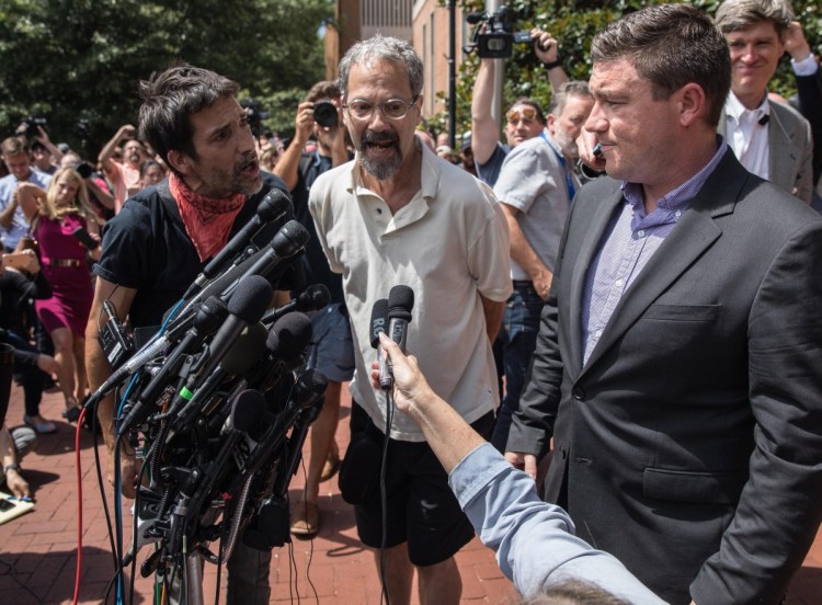 Protesters shout at Jason Kessler, right, during a news conference outside City Hall in Charlottesville, Va., on Aug. 13, a day after an alt-right rally turned into mayhem.