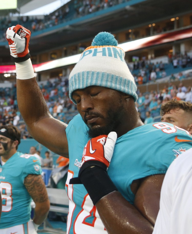 Defensive end Robert Quinn of the Miami Dolphins raises his right fist during the national anthem before Thursday night's game.