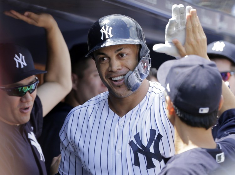 Giancarlo Stanton of the New York Yankees is welcomed Sunday after hitting his fifth home run in the last six games. New York beat Texas, 7-2.