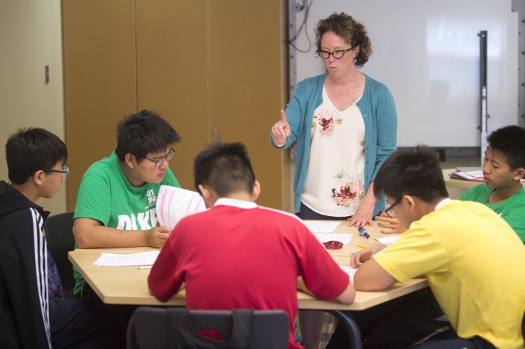 Kathryn Will-Dubyak, an assistant professor in literacy education, works with a group of students from HKMA David Li Kwok Po College in Hong Kong during an English-language learners class at the Kalikow Education Center at the University of Maine at Farmington.