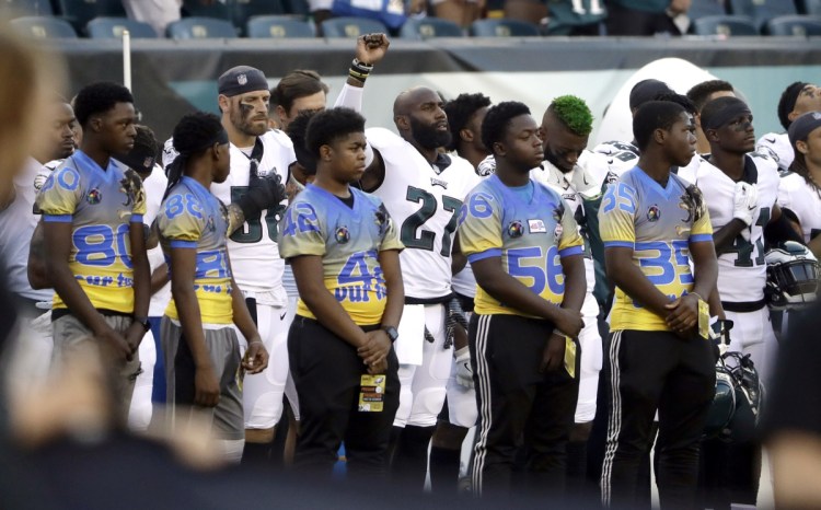 Philadelphia's Malcolm Jenkins, center left, raises his fist during the national anthem before the Eagles' preseason game on Thursday in Philadelphia. The protests seeking social justice were started by Colin Kaepernick and Eric Reid, who do not have jobs in the NFL.