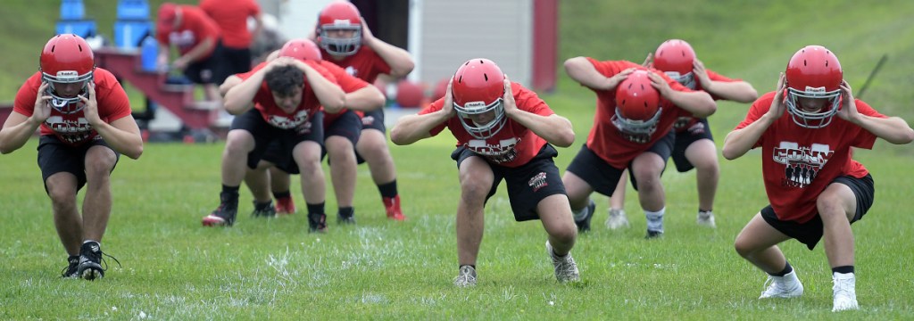 Cony High School football players work through some drills during practice Monday morning in Augusta. Monday marked the first day fall sports teams could start practicing.
