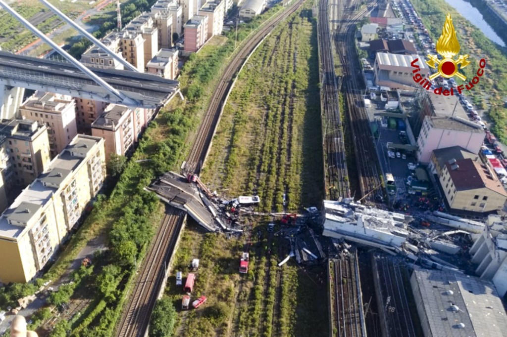 In this photo released by the Italian firefighters, rescue teams work among the rubble of the collapsed Morando highway bridge in Genoa, northern Italy, Tuesday, Aug. 14, 2018. A bridge on a main highway linking Italy with France collapsed in the Italian port city of Genoa during a sudden, violent storm, sending vehicles plunging 90 meters (nearly 300 feet) into a heap of rubble below. (Vigili Del Fuoco via AP)