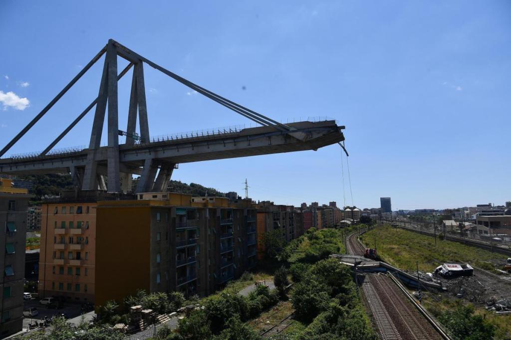 Evacuated housing is visible Wednesday under the remains of the collapsed Morandi highway bridge in Genoa, Italy.