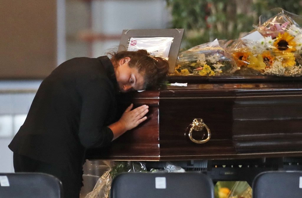 A woman mourns a victim of the collapsed highway bridge Friday at the Fiera di Genova exhibition center, where some of the coffins are laid in state in Genoa, Italy.