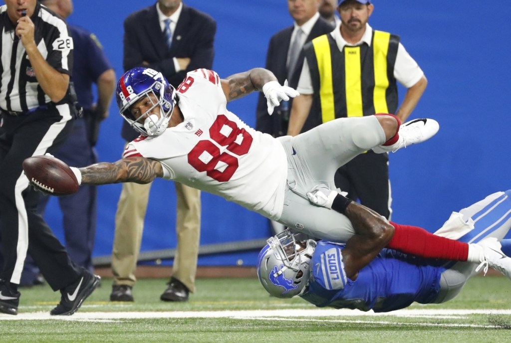 Giants tight end Evan Engram stretches for extra yardage as he's tackled by Lions defensive back Tavon Wilson during a preseason game in Detroit. The Giants won, 30-17.