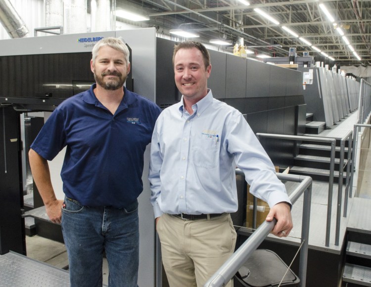 Press room manager Randy Robbins, left, and President and CEO Jon Tardiff pose with the new Heidelberg press in Augusta.