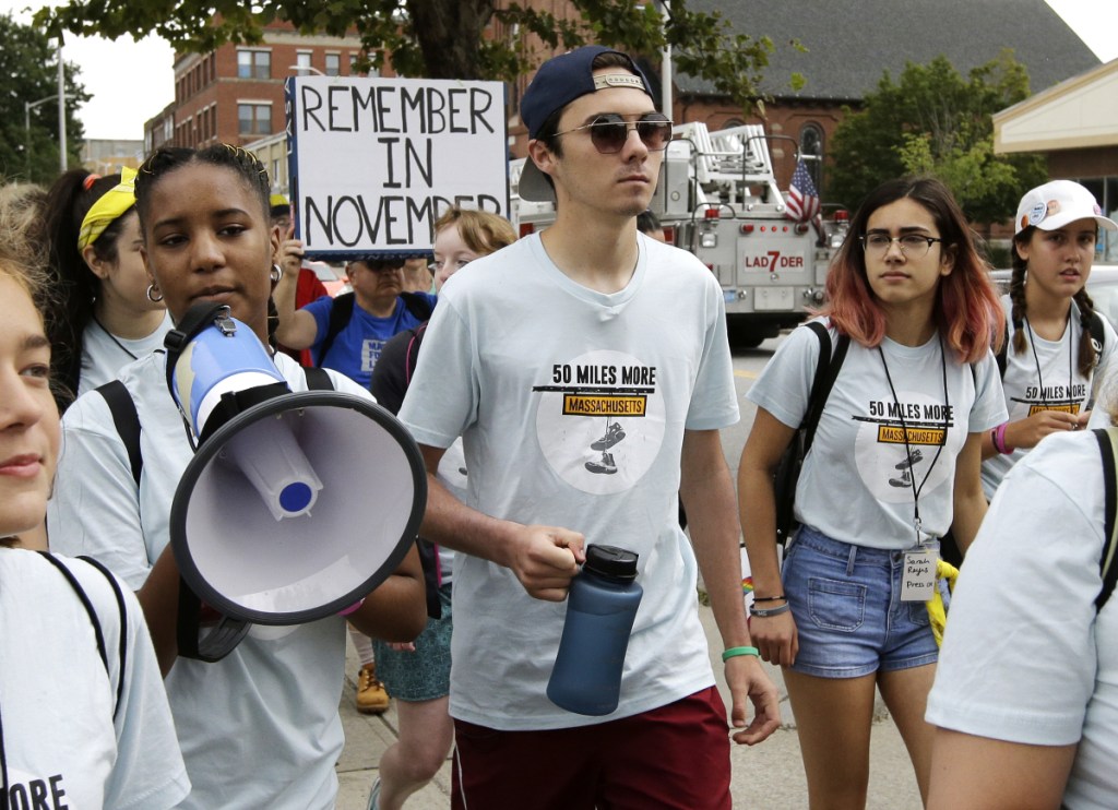 David Hogg, center, a survivor of the school shooting at Marjory Stoneman Douglas High School in Parkland, Fla., walks in a planned 50-mile march Thursday in Worcester, Mass. The march is being held to call for gun law reforms.