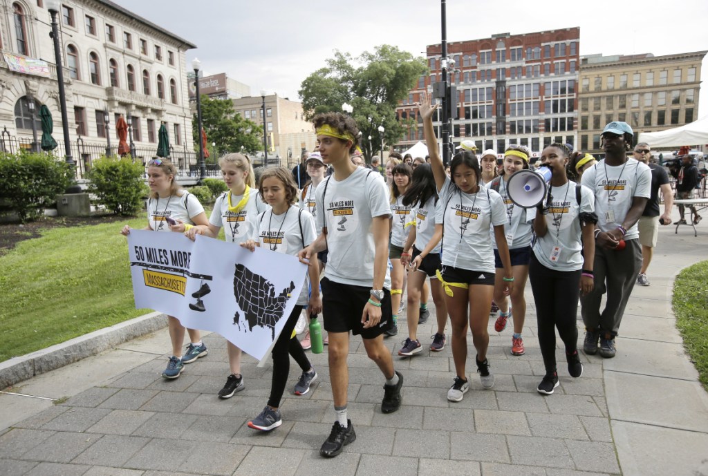 Griffin Gould, 16, an Arlington, Mass., high school student, center, walks with others as they depart Worcester Common in Worcester, Mass., at the start of a planned 50-mile march Thursday.