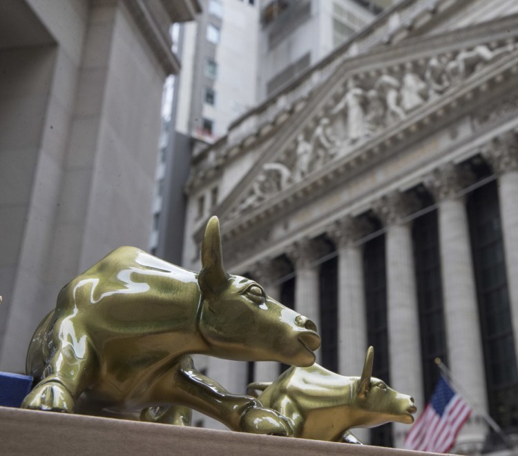 Replicas of Arturo Di Modica's "Charging Bull" are for sale on a street vendor's table outside the New York Stock Exchange in New York.