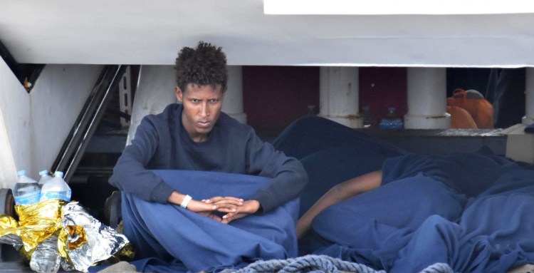 One of about 150 migrants waits aboard the Italian Coast Guard ship Diciotti moored in Catania, Italy, on Wednesday. The migrants are caught up in a dispute between Italy and other European Union nations. 