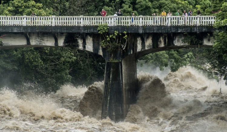 The Wailuku River rages below a bridge in Hilo, Hawaii, on Thursday, as torrents of rain blew in with Hurricane Lane. As much as 35 inches of rain fell in 48 hours.