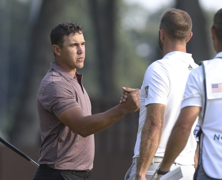 Brooks Koepka, left, shakes hands with Dustin Johnson after the second round of The Northern Trust on Friday. Koepka held a share of the lead with Johnson two strokes back.