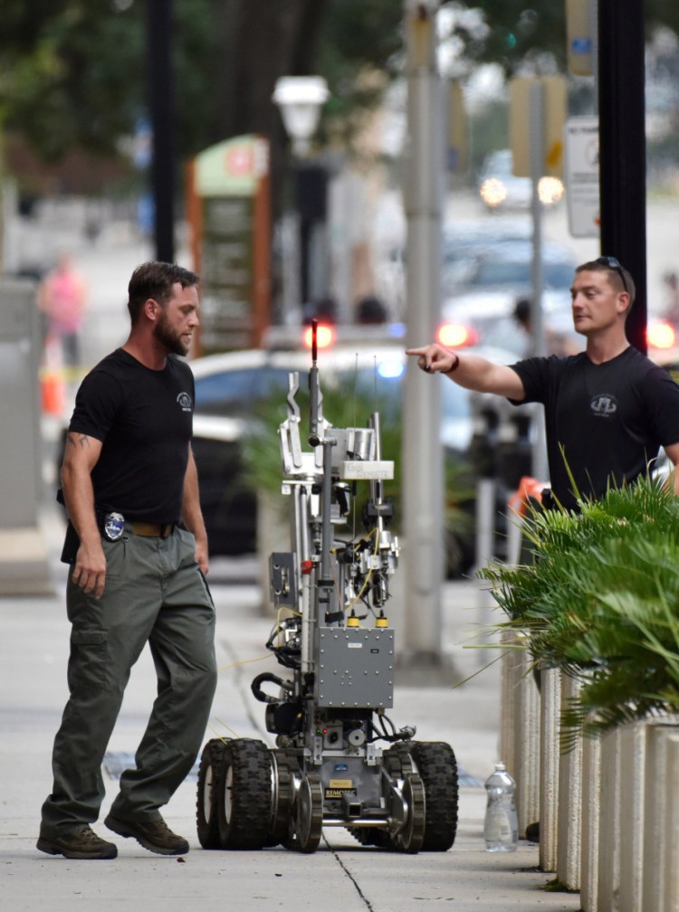 Bomb squad police prepare a robot to enter a parking garage a block away from the scene of a multiple shooting in Jacksonville.