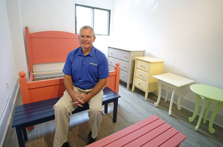 Dave Gallati, director of operations at Maine Woodworks, sits with some finished pieces. Maine Woodworks will open a showroom in Saco for the first time to showcase the pieces crafted by its integrated workforce.