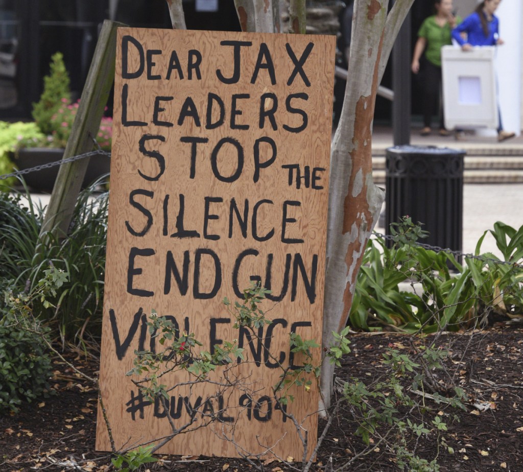 A sign is placed outside the site of a mass shooting Sunday in Jacksonville, Fla.
