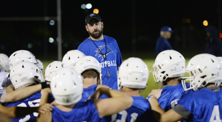 UNE Coach Mike Lichten speaks with his team after its first practice of the season in Biddeford on Aug. 9. At least eight starters played high school football in Maine.