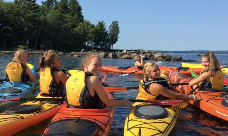 Members of the 2017 Windham girls' soccer team kayaked around Frye Island and rafted together to provide enough stabilty for teammates to walk across the bows of their watercraft.