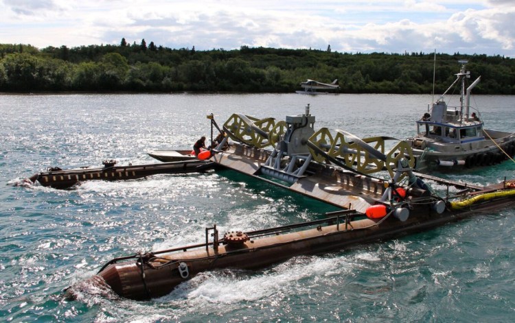 A tugboat maneuvers Ocean Renewable Power Co.'s RivGen Power System into place on the Kvichak River in Alaska. Over a two-year trial, the system provided about a third of the power for a remote village nearby.