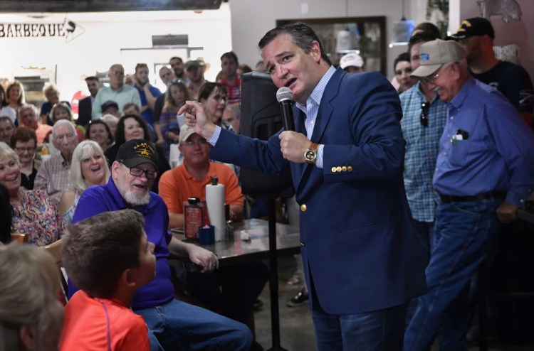 Listeners laugh as U.S. Sen. Ted Cruz jokes about the Democratic Party during a campaign stop Thursday in Abilene, Texas. President Trump will headline a rally in October for the man who has called him 'a sniveling coward.' 
