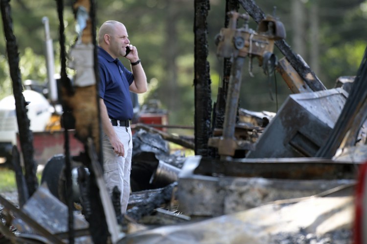A investigator with the Office of the State Fire Marshal on Wednesday examines a residence destroyed by fire on Hunts Meadow Road in Whitefield.