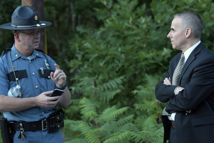 State police Maj. Brian Scott, left, confers Thursday with Lt. Col. William Harwood at the scene where a Massachusetts man, Gyrth Rutan, shot himself to death on Timberwood Drive in Gardiner. A woman's body was found in the trunk of a car Rutan had been driving.