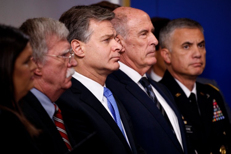 FBI Director Christopher Wray listens during the daily press briefing at the White House, Thursday, Aug. 2, 2018, in Washington. From left also listening are White House press secretary Sarah Huckabee Sanders, national security adviser John Bolton, Wray, Director of National Intelligence Dan Coats, and National Security Agency Director Gen. Paul Nakasone. 