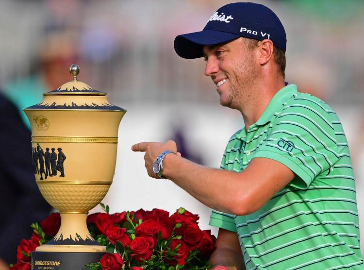 Justin Thomas points the Gary Player Cup trophy after winning the Bridgestone Invitational on Sunday at Firestone Country Club in Akron, Ohio. 