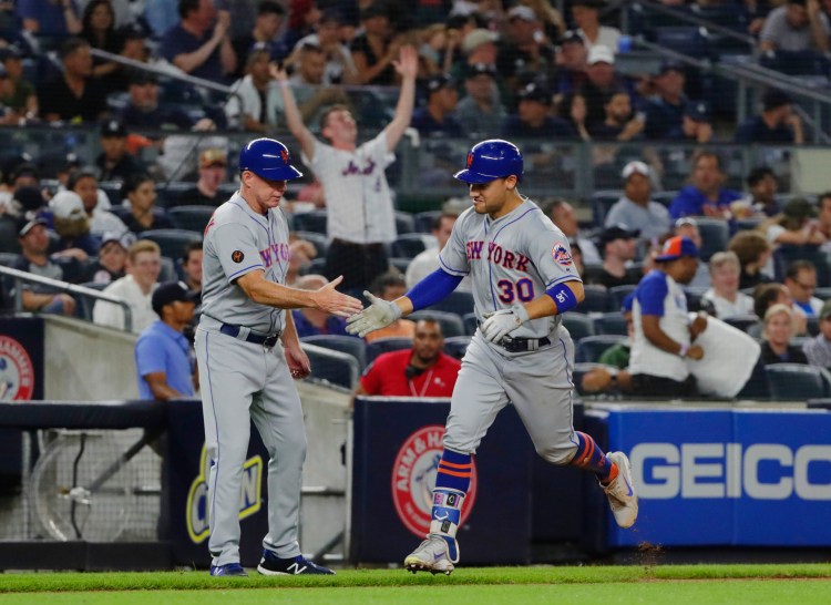 New York Mets' Michael Conforto, right, celebrates with third base coach Glenn Sherlock after hitting one of the Mets five home runs in their win over the Yankees on Monday in New York.
