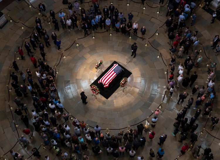 Members of the public walk past the flag-draped casket bearing the remains of John McCain of Arizona, who lived and worked in Congress over four decades, in the U.S. Capitol rotunda in Washington, Friday, Aug. 31, 2018. McCain was a six-term senator from Arizona, a former Republican nominee for president, and a Navy pilot who served in Vietnam where he endured five-and-a-half years as a prisoner of war. 