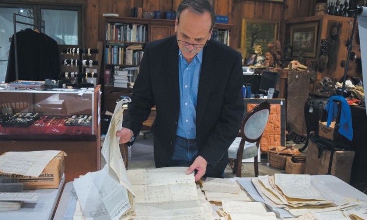 Daniel Buck Soules examines documents related to Crooker shipping at his auction house in Lisbon Falls.