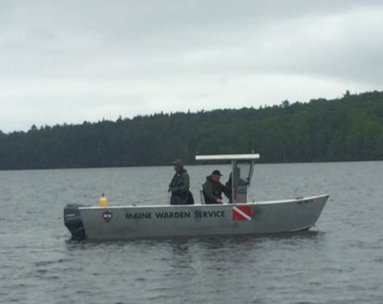 A Maine Warden Service dive boat pulls divers underwater in Moosehead Lake while searching for a missing man Saturday.
