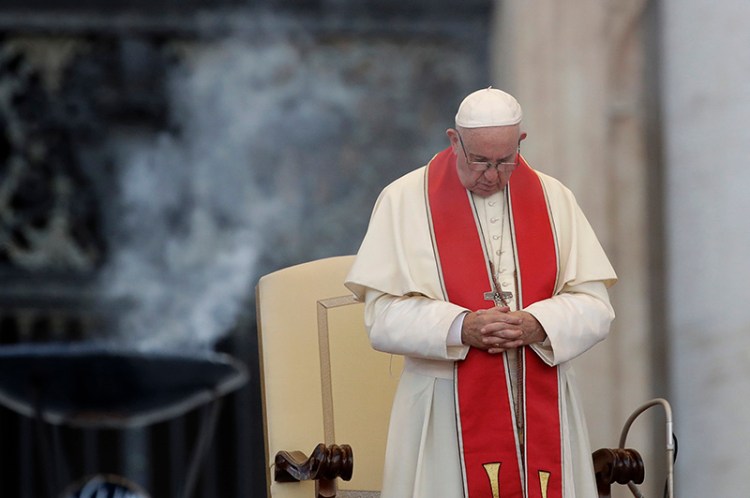 Pope Francis prays during an audience in St. Peter's square at the Vatican on Tuesday.
