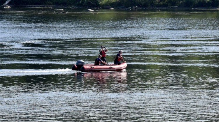 Skowhegan Fire Capt. Rick Caldwell, front, scans the Kennebec River with two other firefighters searching for the driver of a vehicle that crashed off Water Street early on Sunday. Police say the man then jumped out of the vehicle and climbed down a steep embankment at the river's edge. Caldwell said the search was called off by mid-afternoon.
