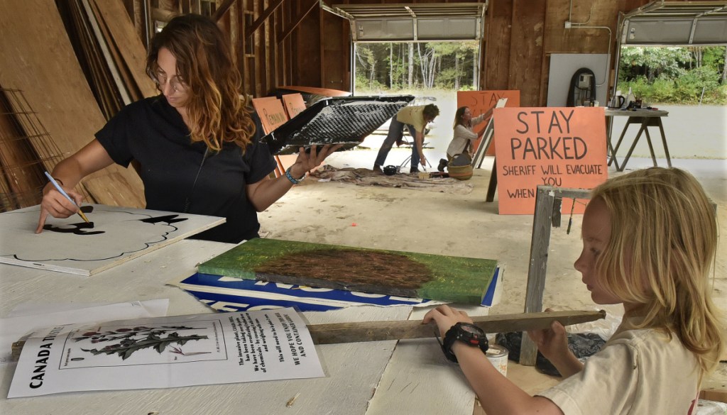Jennifer Sansosti and Luca McCune work on signs with others in preparation for the Maine Organic Farmers and Gardeners Association annual Common Ground Country Fair in Unity on Tuesday. The three-day fair starts Friday.