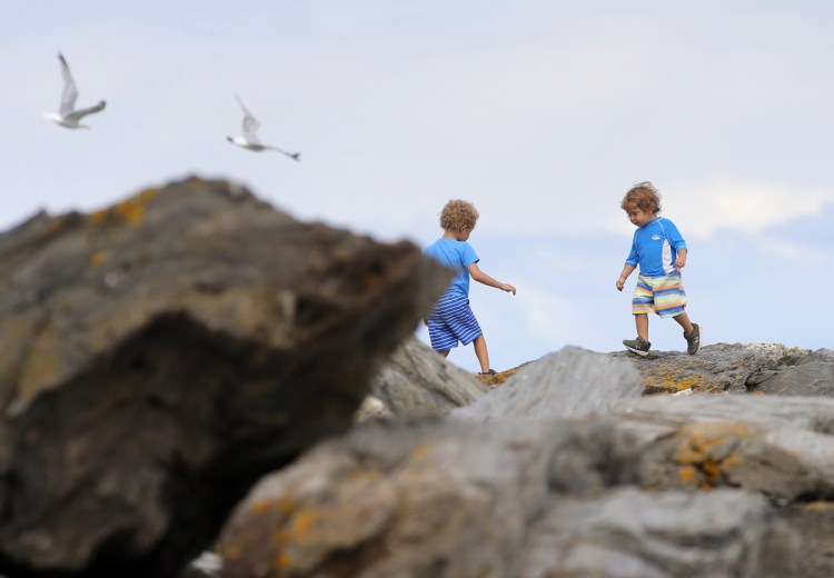 Brothers Rylan, left, and Macen of New Gloucester play on the rocks at Two Lights State Park in Cape Elizabeth on Thursday. 