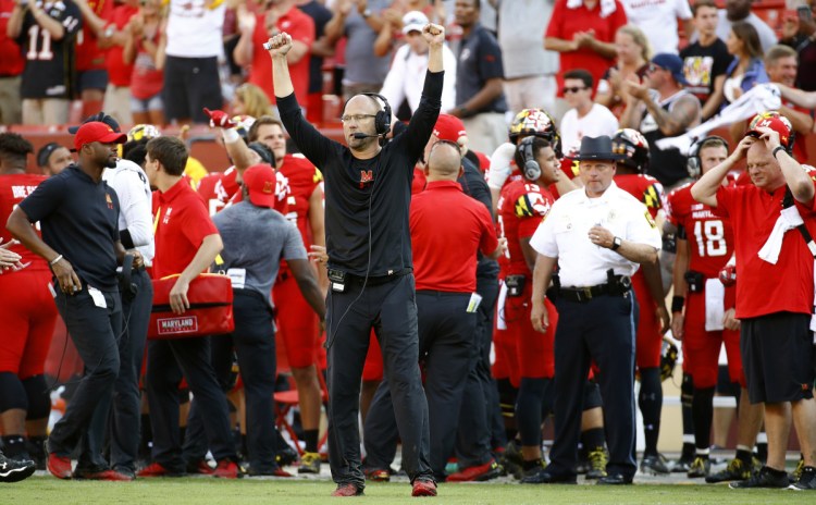 Maryland interim coach Matt Canada, center, celebrates in the final moments of the Terrapins' 34-29 upset over No. 23 Texas on Saturday in Landover, Maryland. The Terrapins had a rocky offseason, which included the death of offensive lineman Jordan McNair and charges of bullying by the coaching staff.