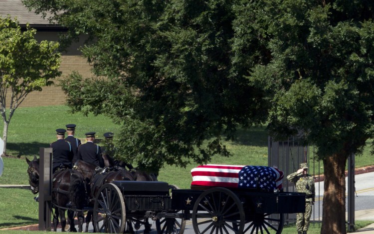 A horse-drawn caisson carries the casket containing Sen. John McCain, R-Ariz., to his burial site at the U.S. Naval Academy Cemetery in Annapolis, Md., on Sunday. McCain died Aug. 25 from brain cancer at age 81.