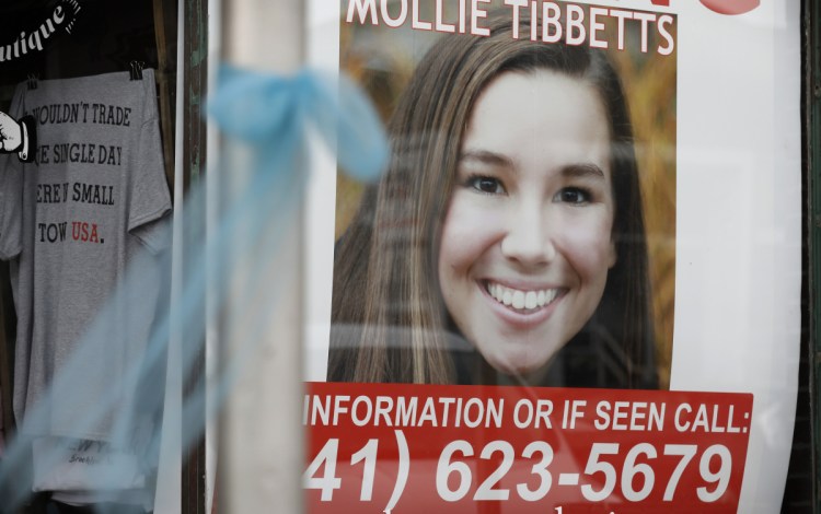 A poster for University of Iowa student Mollie Tibbetts hangs in the window of a business in Brooklyn, Iowa. 