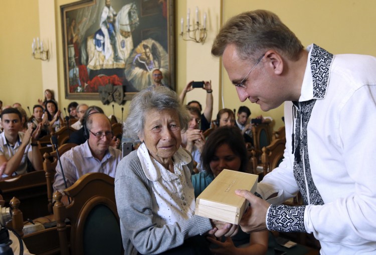 Lviv Mayor Andriy Sadoviy, right, presents a glass copy of an old metal synagogue key to Yanina Hescheles, Polish writer and a Nazi concentration camp survivor, at a ceremony Sunday commemorating the 75th anniversary of the annihilation of the city's Jewish population by Nazi Germany in Lviv, Ukraine. 